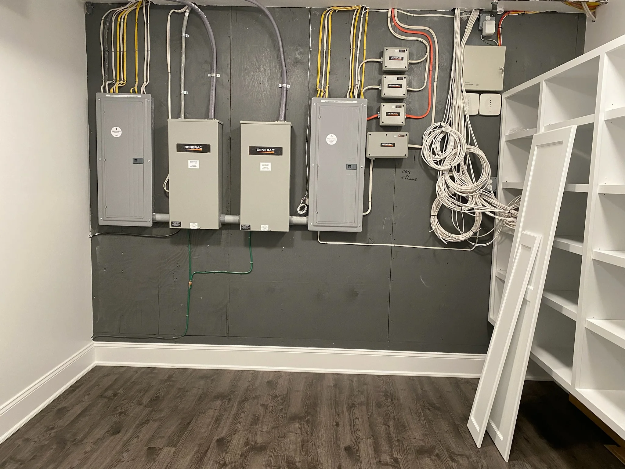 Electrical panel with Generac switches, sub-panels, circuit breakers, and organized wiring